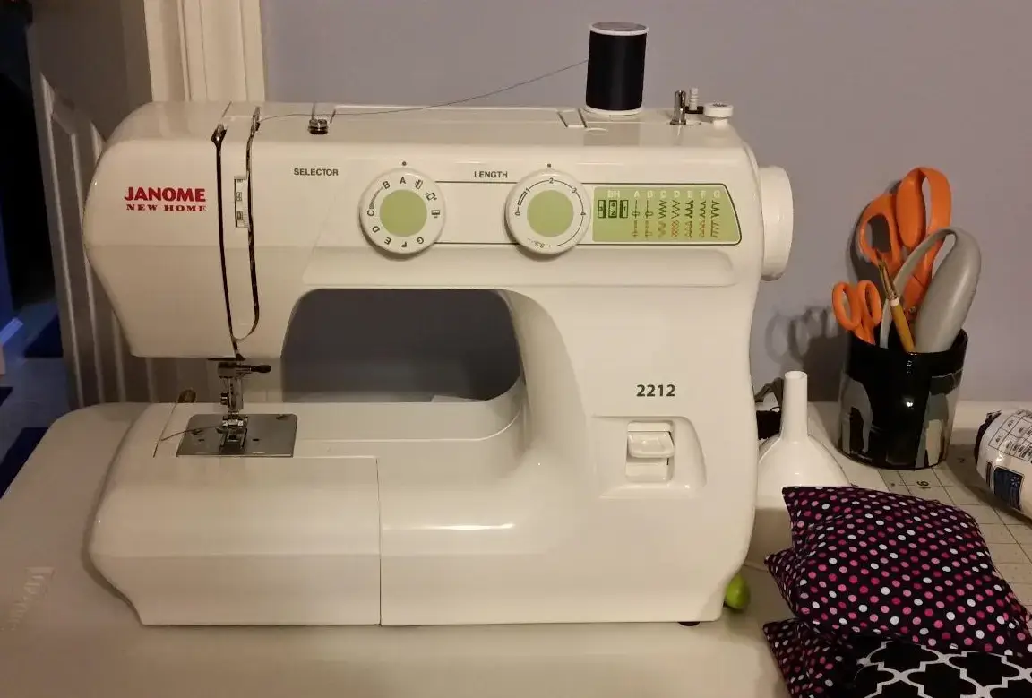 Front view of the white Janome 2212 sewing machine for beginners, showing its simple stitch selection dial.